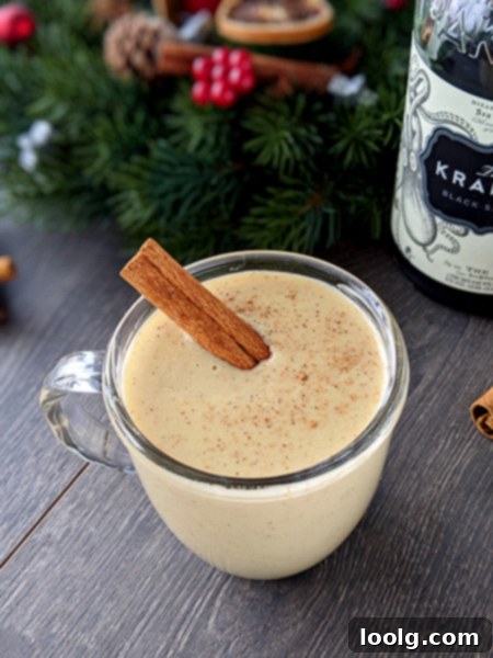 Healthy Eggnog Classic and Plant-Based 2 Two glasses of healthy homemade eggnog, garnished with cinnamon sticks and a sprinkle of nutmeg, set against a festive, cozy background, highlighting its rich and creamy texture.