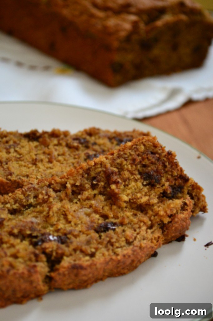 Healthy Whole Wheat Banana Bread Slices Several slices of freshly baked whole wheat chocolate chip banana bread on a wooden board, with a focus on the rich color and texture.