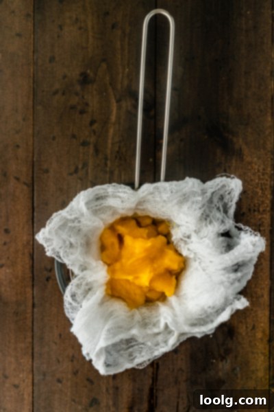 Crafting Homemade Pumpkin Puree 9 Pumpkin puree draining in a cheesecloth-lined sieve over a bowl