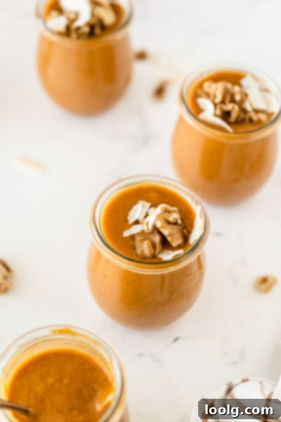 Velvet Pumpkin Dream 4 overhead photo of several jars of pumpkin pudding that is sweetened with honey garnished with coconut slivers and toasted walnuts