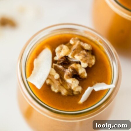 Velvet Pumpkin Dream 6 overhead photo of a jar of pumpkin pudding that is sweetened with honey garnished with coconut slivers and toasted walnuts