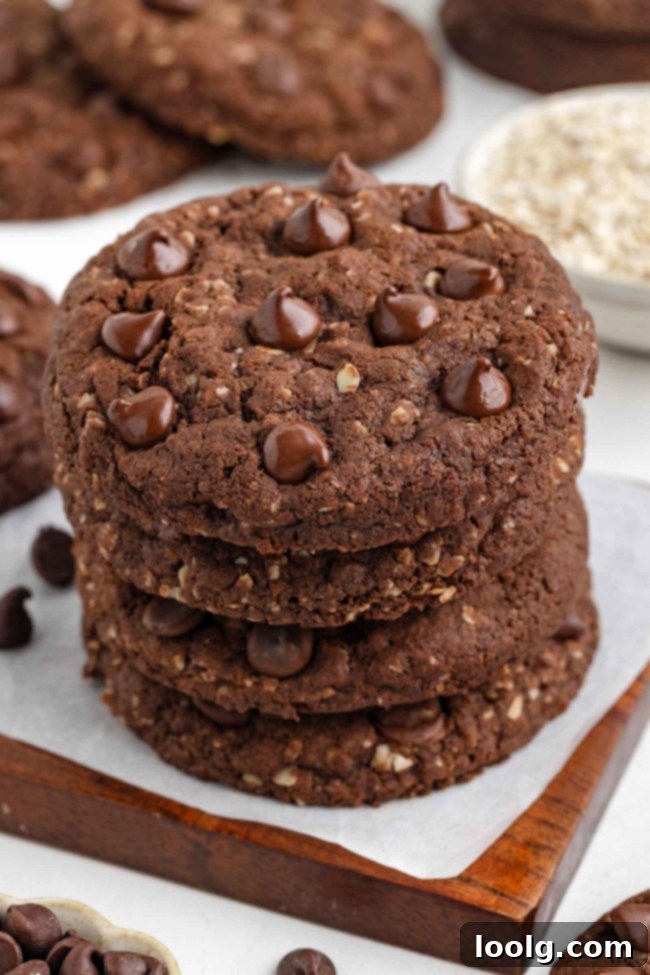 Close-up of a stack of cocoa oatmeal cookies on a white table with more cookies in the background