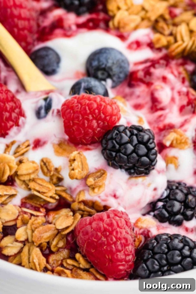 Close-up of a granola bowl filled with creamy yogurt and fresh berries