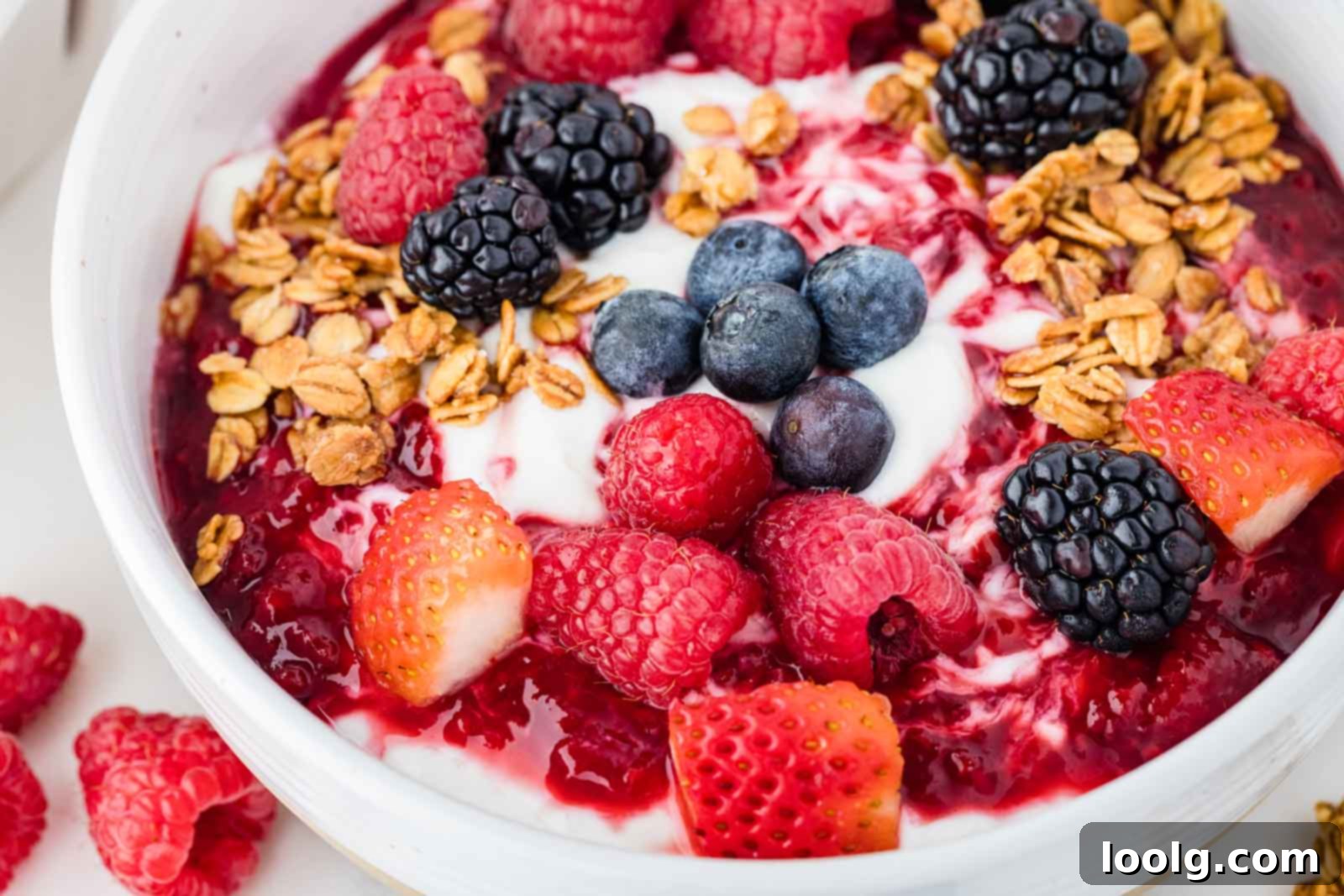 Close-up of yogurt bowls topped with mixed berries and crunchy granola