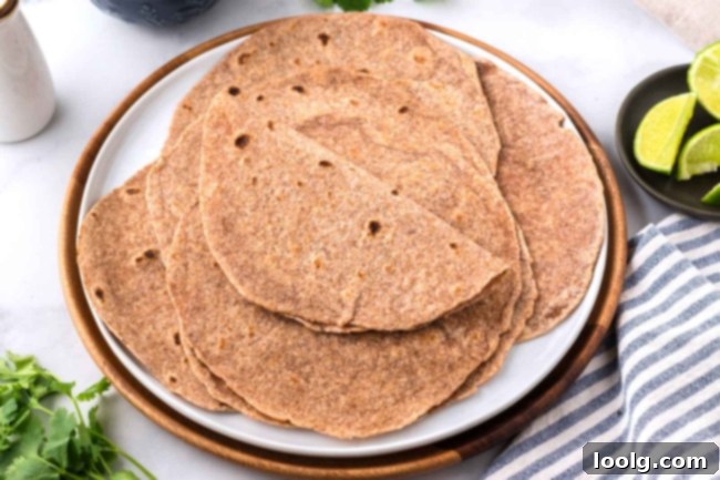 A beautifully arranged stack of whole wheat tortillas on a white plate with a napkin, inviting users to imagine the delicious meals they can create