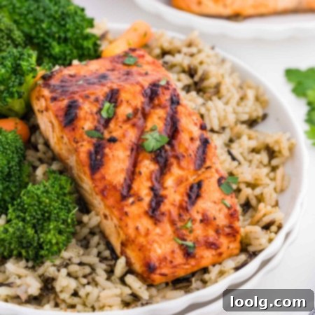 Grilled Salmon Perfection 8 Close-up of a beautifully grilled BBQ salmon fillet, plated with wild rice and fresh broccoli, ready to serve.