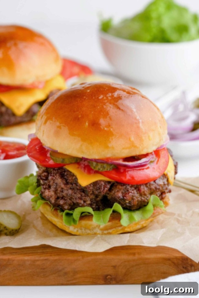 close-up up air fryer burger on piece of parchment paper and another burger in the background