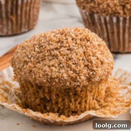 close-up of sourdough cinnamon muffin on a white table with more muffins in background