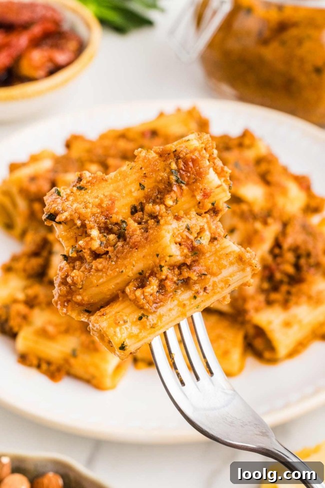 fork digging into sun-dried tomato pesto pasta
