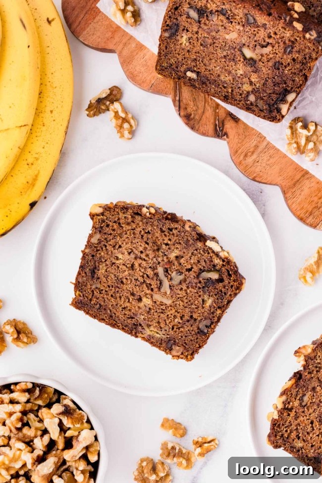 Slice of whole wheat banana nut bread on a white plate