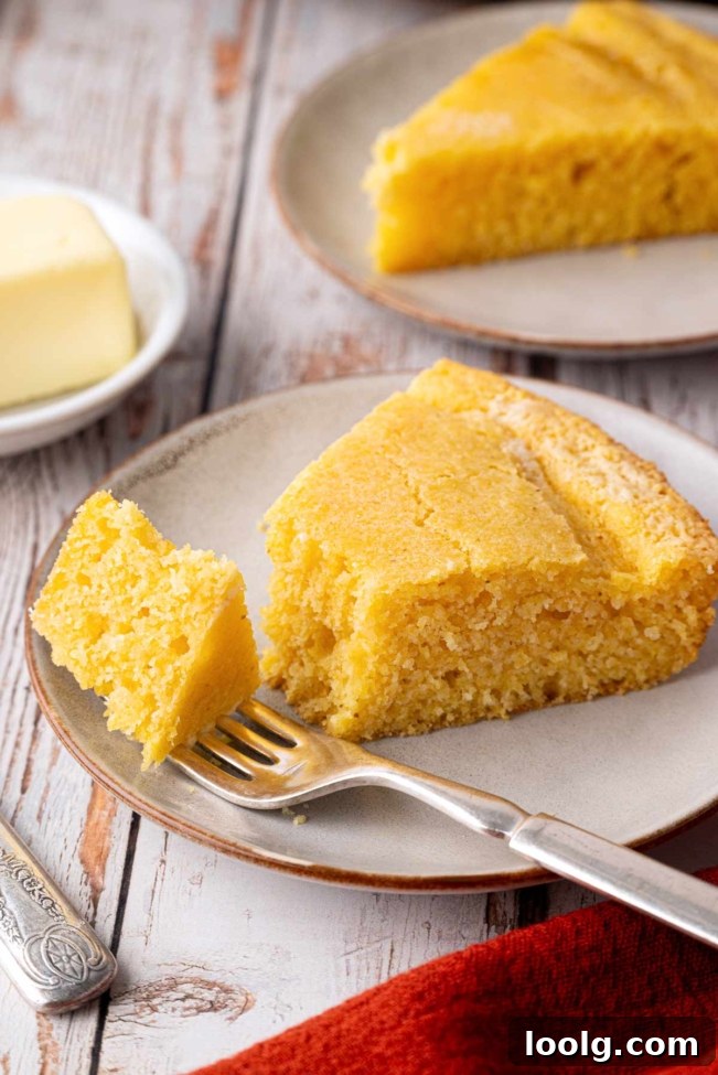 Slice of sourdough cornbread on a plate with a fork and butter