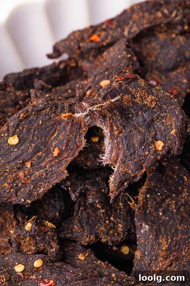 Homemade Smoky Venison Jerky Recipe 11 Close-up of dark, spiced venison jerky pieces, showcasing their texture and seasoning.