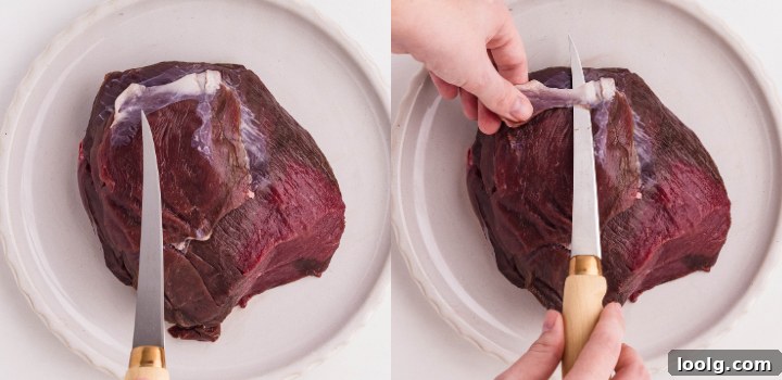 Homemade Smoky Venison Jerky Recipe 4 Slicing a raw venison roast to prepare for making venison jerky.